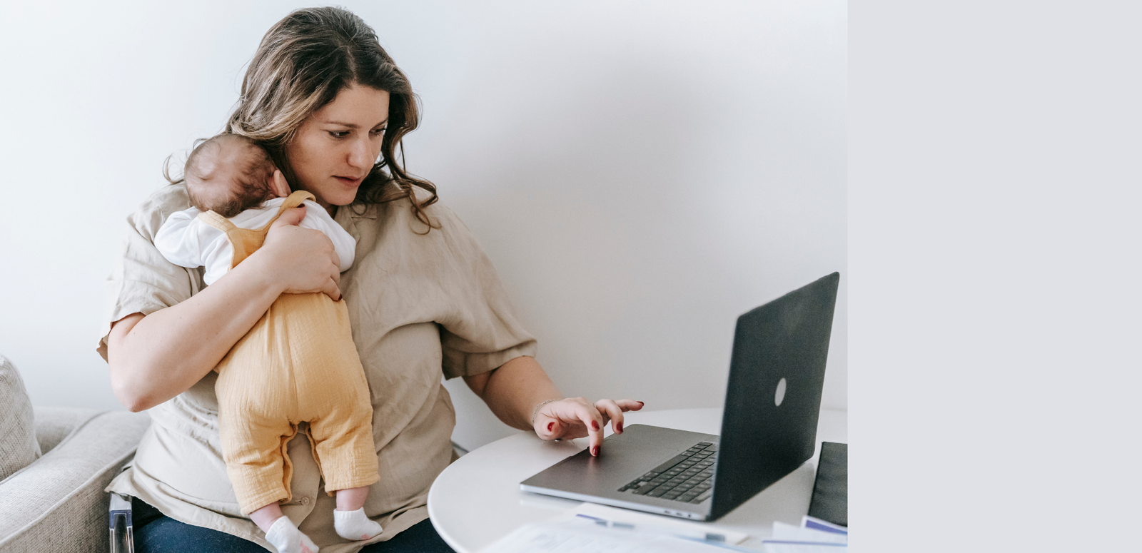Mãe empreendedora trabalhando em casa com o bebê no colo, representando como vender mais sem perder tempo